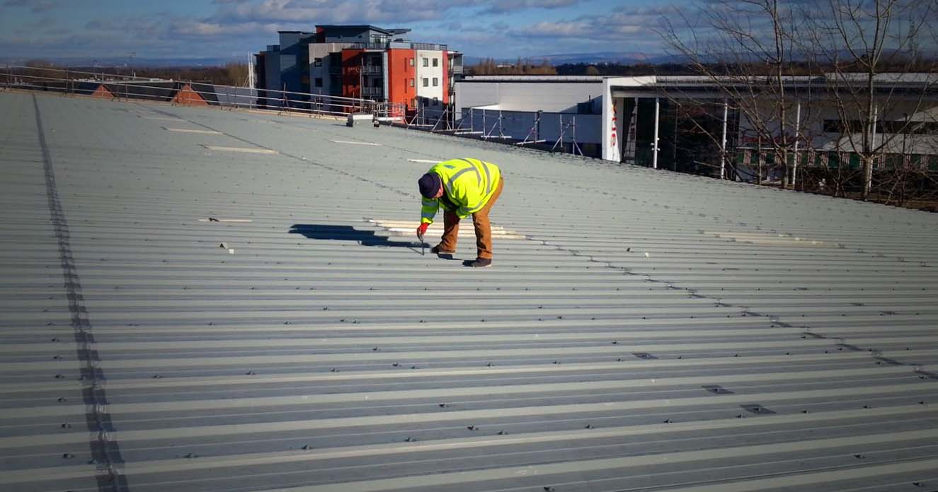 technician carrying out steel factory roof inspection work substrate corrosion detection