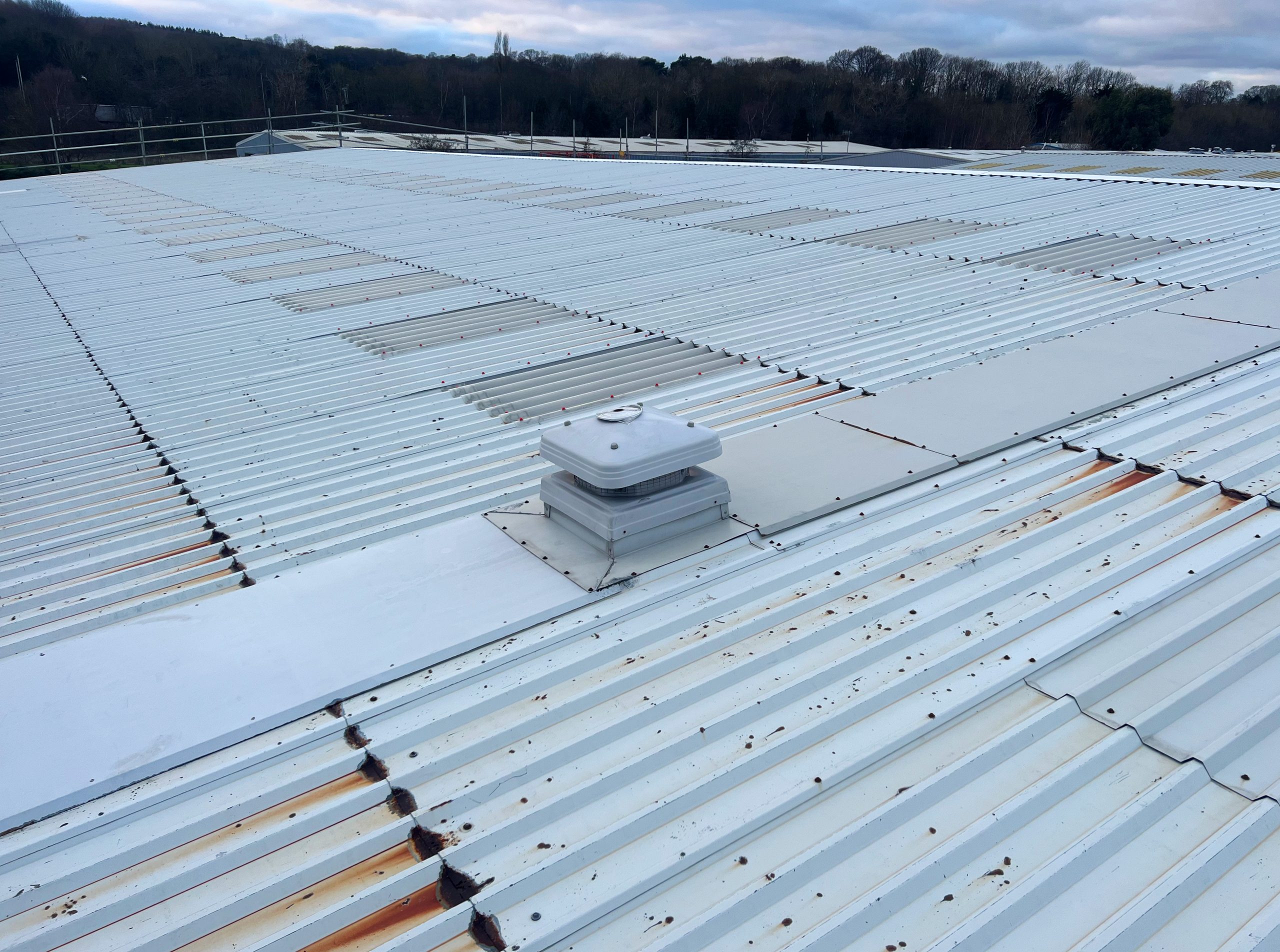 Pre-works condition survey photograph of a large office building PVF2 roof in Gateshead, showing extensive cut edge corrosion, rust staining and pitting corrosion across the profiled steel roof sheets
