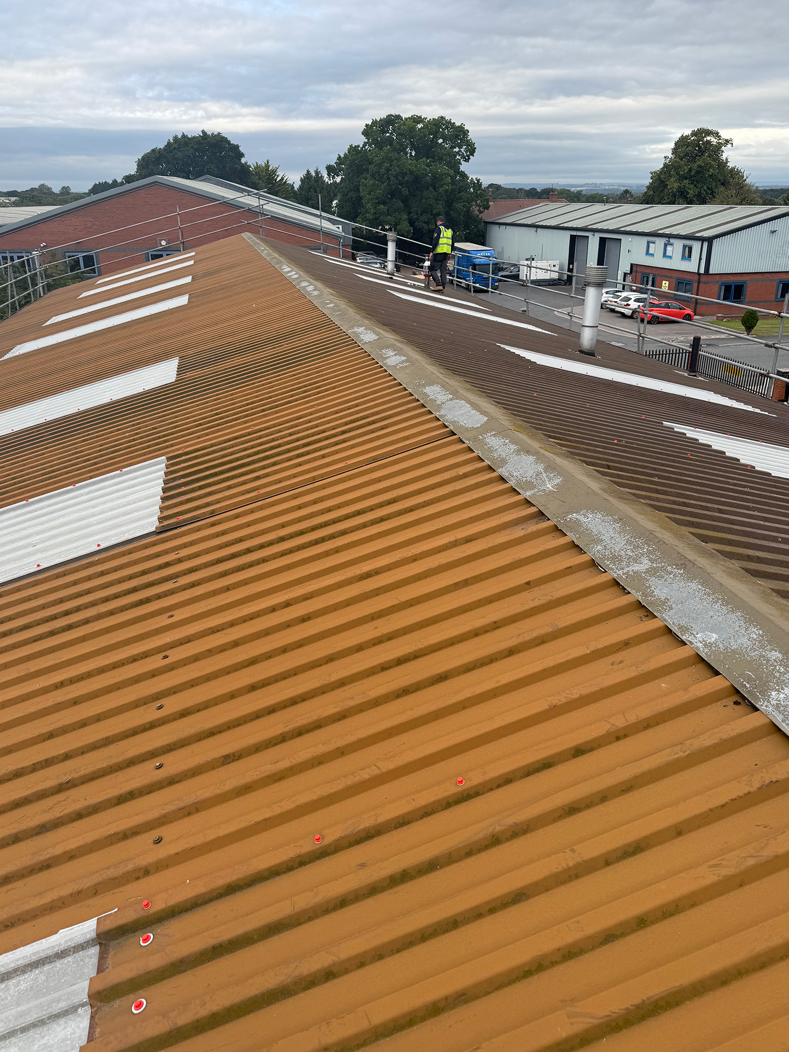 Corroded steel corrugated roof sheets with delaminated paint before coating works