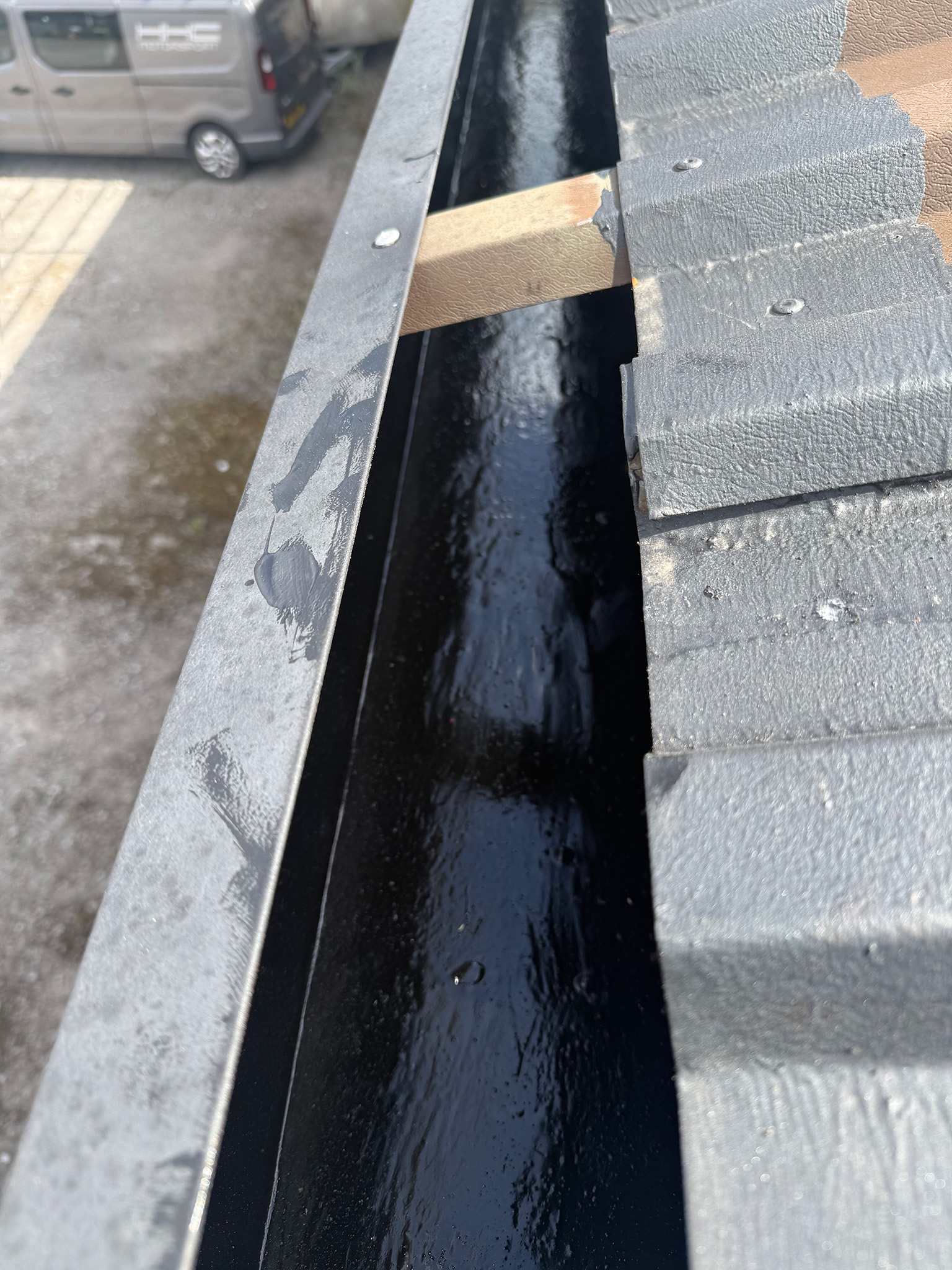 Commercial gutter channel with mastic seal and primed sheet ends before roof coating