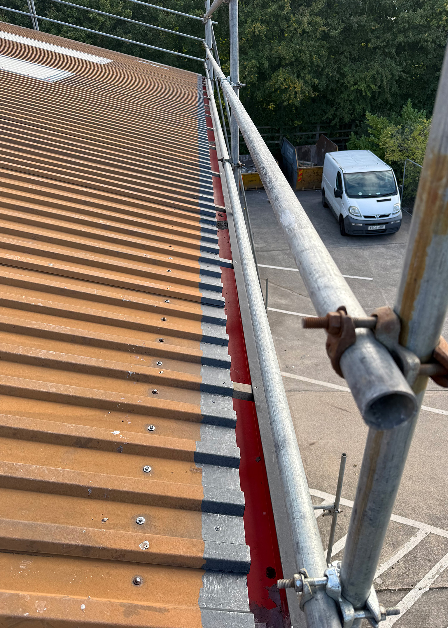 Scaffolding and edge protection installed on a commercial roof with sheet edges primed