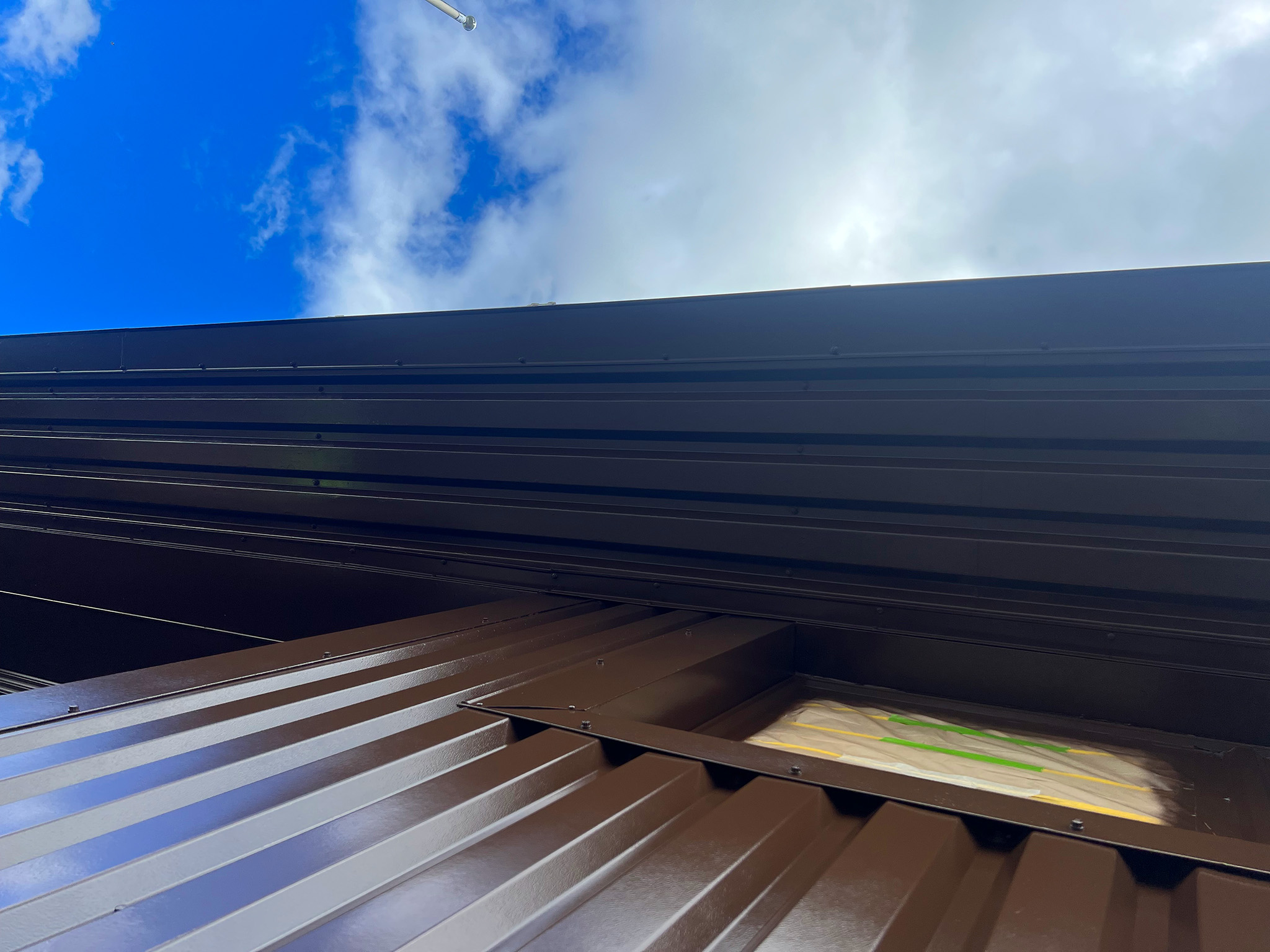 Completed cladding and soffit coating viewed from below along the roofline