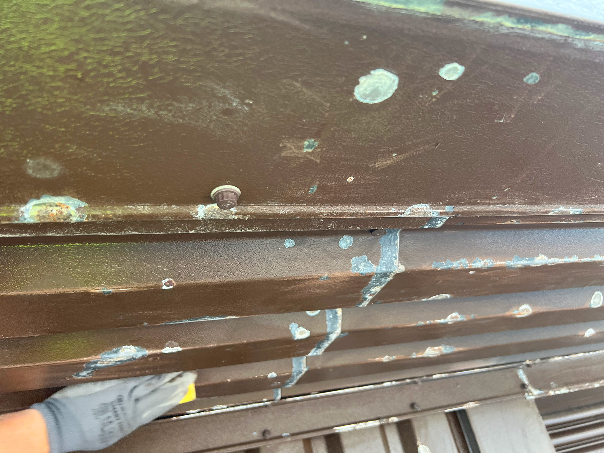 Sanding work in progress on soffit to remove loose and flaking paint at Bodelwyddan
