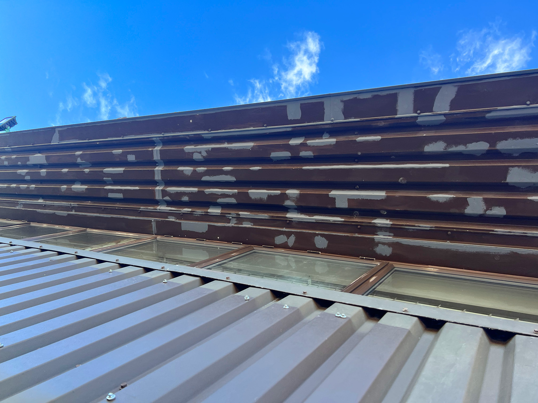 Spot primer coating applied across soffit area to prepare for top coats