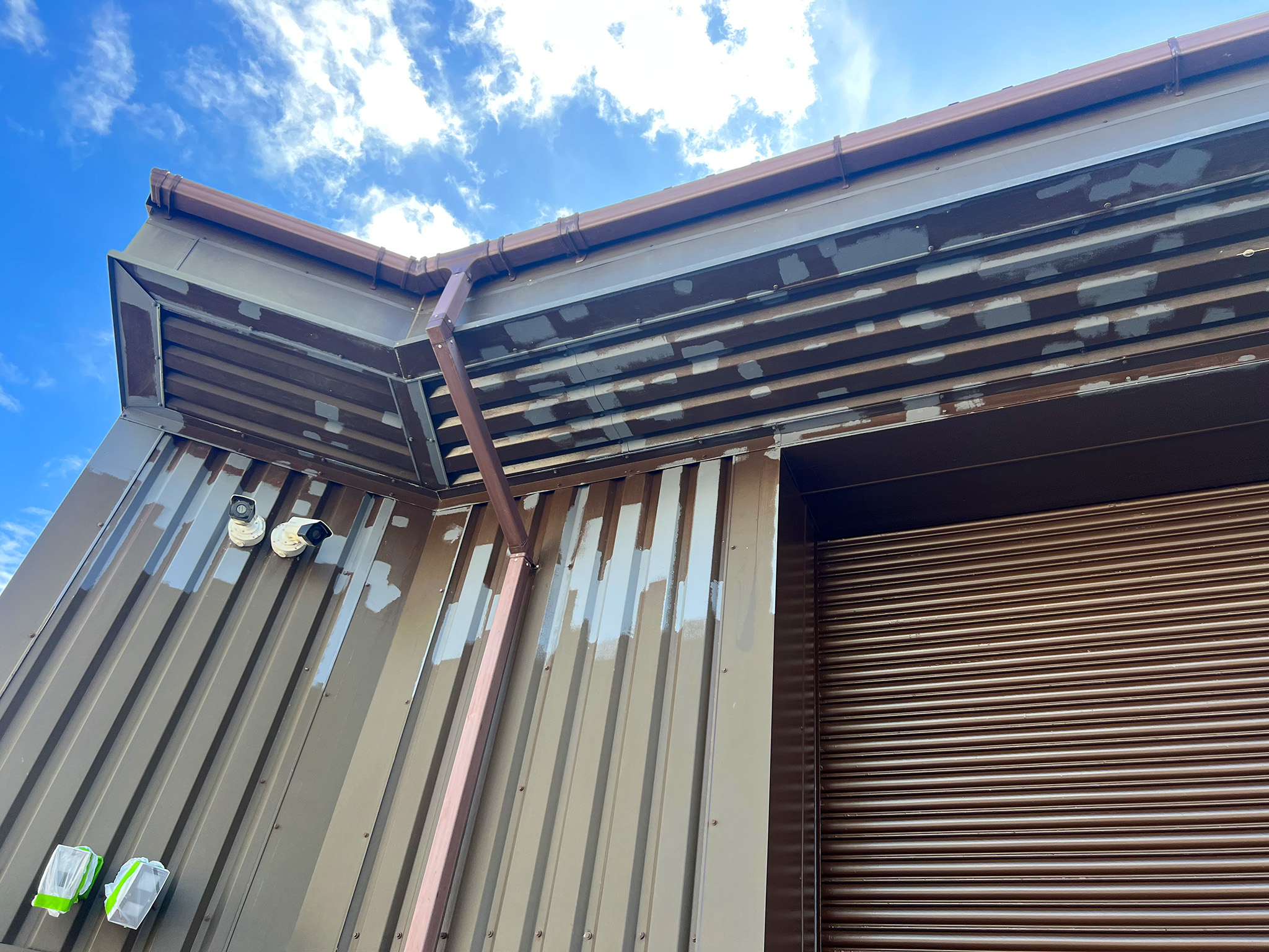 Spot primer applied to soffit corner detail ready for top coats above roller shutter