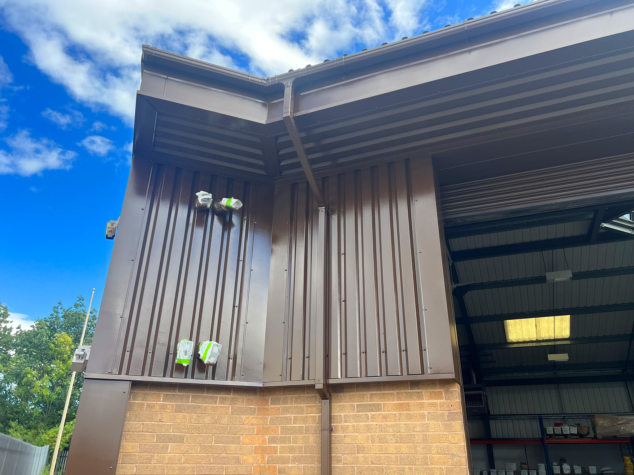 Spray applied Tikkurila Temadur 20 chestnut and mahogany brown to gutters and cladding corner detail