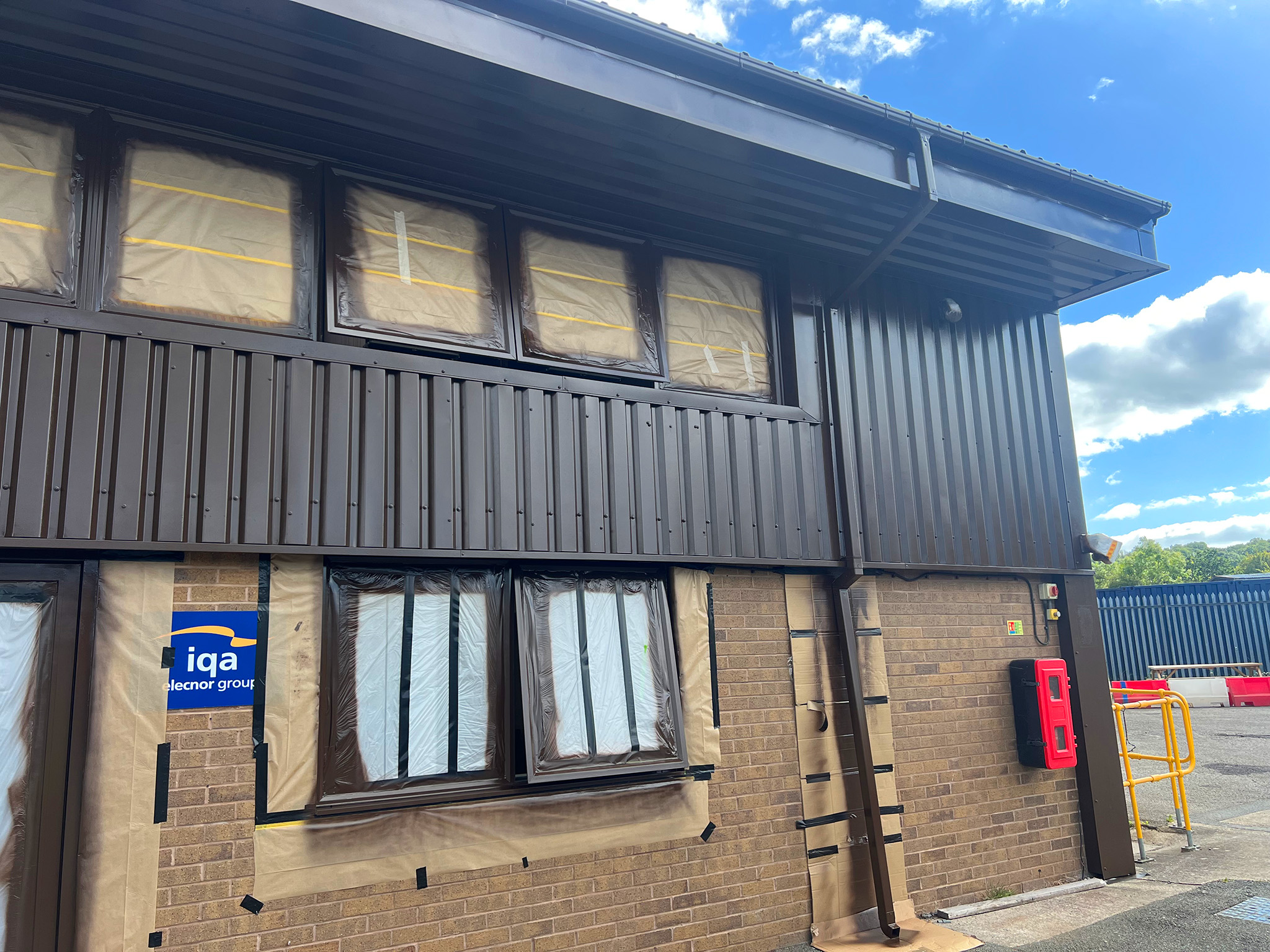 Spray applied Tikkurila Temadur 20 chestnut and mahogany brown to office cladding and window frames